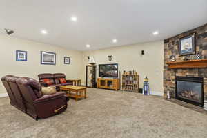 Family room with a fireplace, recessed lighting, and light carpet
