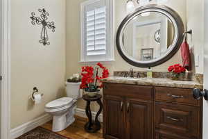 1/2 Bathroom with light wood-style floors and vanity