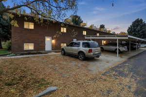 View of front facade featuring brick siding and covered parking