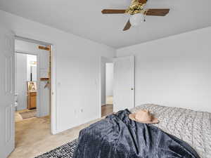 Carpeted bedroom with a walk in closet and a ceiling fan