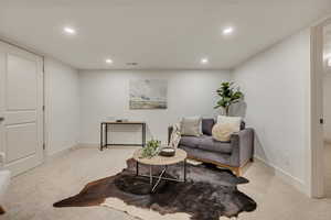 Living area featuring light carpet and recessed lighting