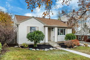 View of front facade with roof with shingles and a chimney