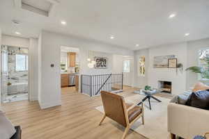 Living room with light wood-style floors, recessed lighting, and a fireplace