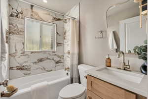 Full bathroom featuring shower / bath combo with shower curtain and vanity