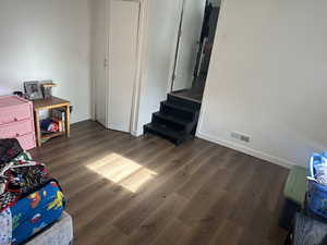 Recreation room featuring dark wood-type flooring and baseboards