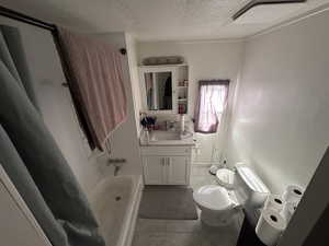 Bathroom with vanity, a textured ceiling, and light tile patterned floors