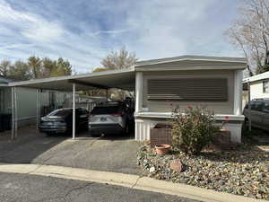 View of parking featuring an attached carport and driveway