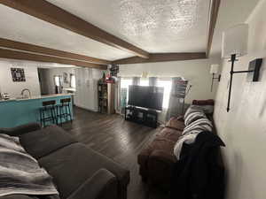 Living room with a textured ceiling and dark wood-style flooring