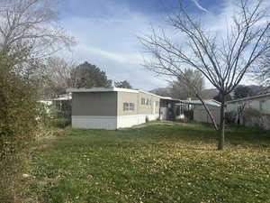 View of home's exterior featuring a lawn and a storage shed