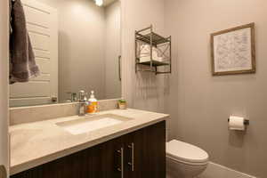 Half bathroom featuring vanity and toilet