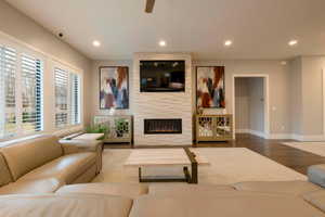 Living area featuring wood finished floors, recessed lighting, and a fireplace