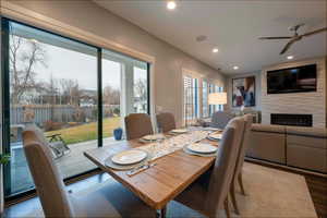 Dining area with a fireplace, ceiling fan, recessed lighting, and wood finished floors