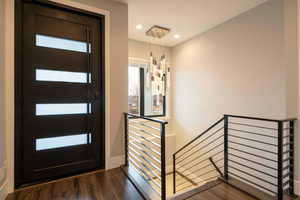 Foyer with dark wood-style floors and recessed lighting