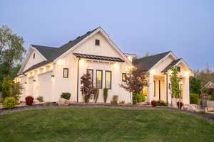 Modern farmhouse with a front yard, a standing seam roof, board and batten siding, and a metal roof