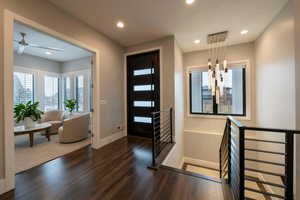 Foyer entrance with dark wood finished floors and recessed lighting