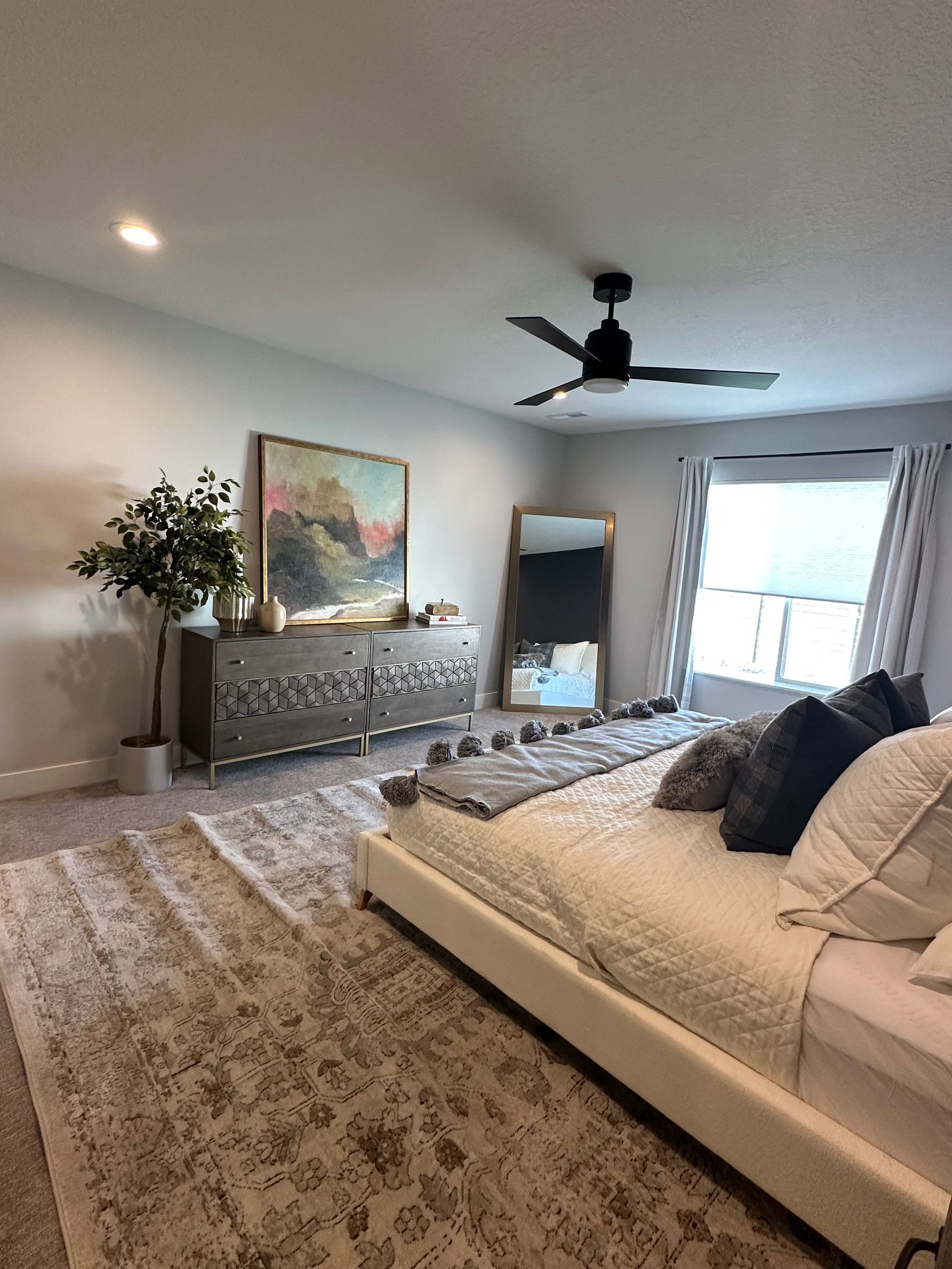 Carpeted bedroom featuring ceiling fan and baseboards