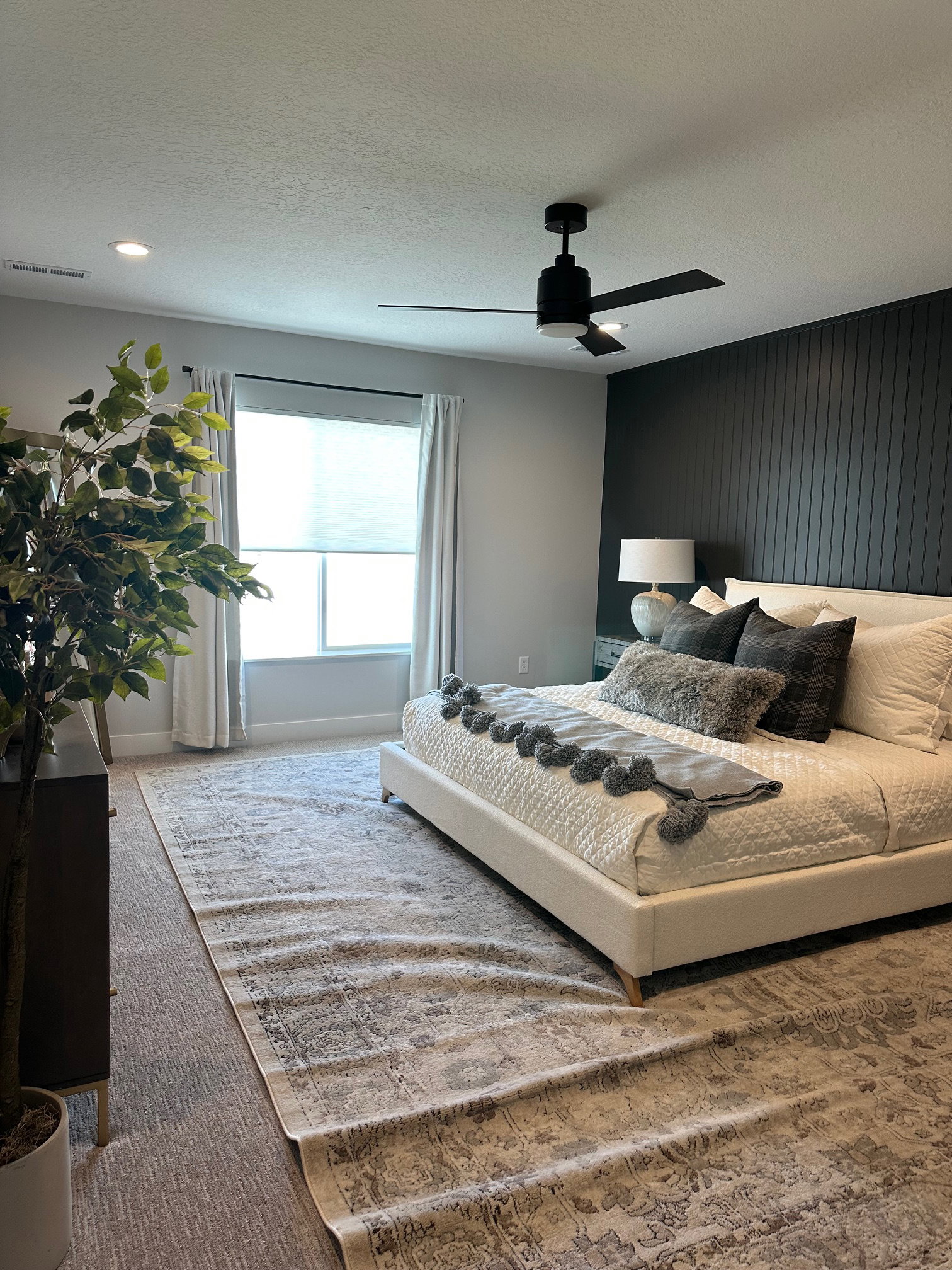 Carpeted bedroom featuring a textured ceiling and a ceiling fan