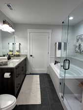 Full bath featuring vanity, a garden tub, a shower stall, dark tile patterned floors, and recessed lighting