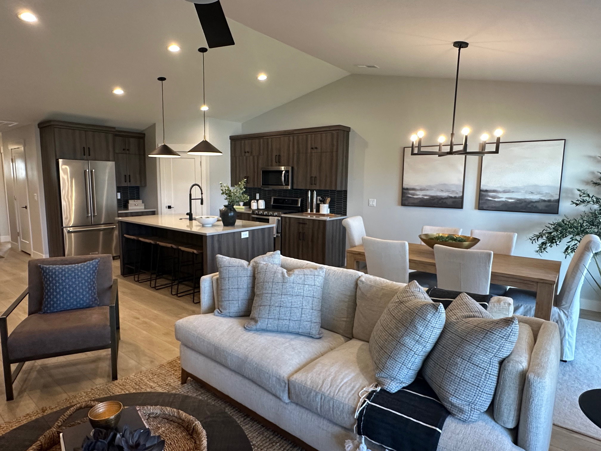 Living area featuring lofted ceiling, light wood finished floors, recessed lighting, and a chandelier