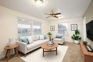 Living area featuring ceiling fan, light colored carpet, and a textured ceiling