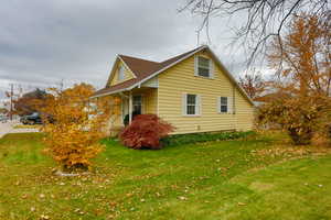 View of property exterior with a yard