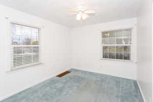 Empty room with carpet and a ceiling fan
