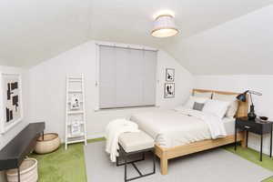 Carpeted bedroom featuring vaulted ceiling and a textured ceiling