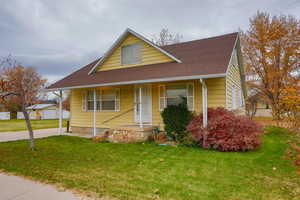 Bungalow featuring a front lawn, a porch, and roof with shingles