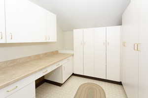 Unfurnished office featuring light floors and built in desk