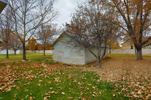 View of side of property with a fenced backyard and an outdoor structure