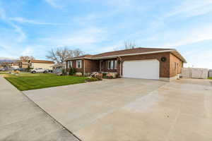 Ranch-style house with brick siding, driveway, covered porch, and a garage