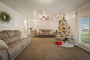 Carpeted Family Room featuring ornamental molding, a ceiling fan, and a textured ceiling