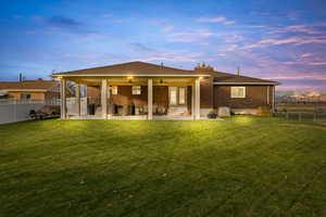 Back of property with a fenced backyard, a patio area, ceiling fan, and brick siding