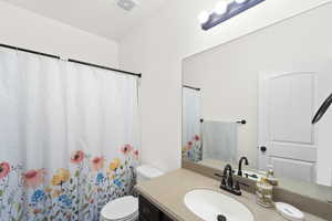 Full bathroom featuring curtained shower and vanity