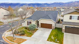 Traditional home featuring a shingled roof, stucco siding, driveway, and a mountain view