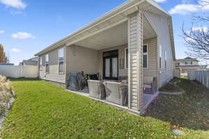 Rear view of property featuring a fenced backyard, a patio, and french doors