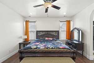Bedroom with multiple windows, dark wood-type flooring, ceiling fan, a textured ceiling, and recessed lighting