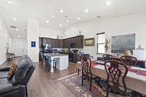 Dining space with recessed lighting, dark wood-style flooring, and high vaulted ceiling