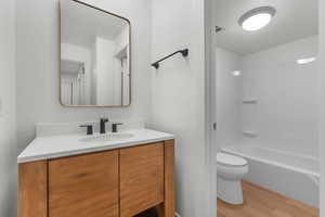 Full bath featuring vanity, wood finished floors, and  shower combination