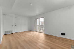 Spare room featuring light wood finished floors and baseboards
