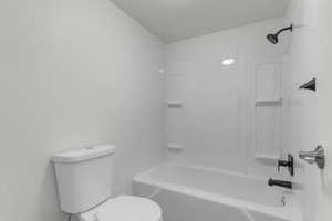 Full bathroom with toilet and bathtub / shower combination