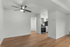 Unfurnished living room with light wood-style flooring and ceiling fan