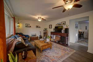Living area featuring a ceiling fan and dark wood finished floors