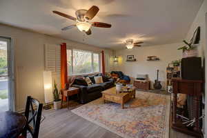 Living room featuring large front window with view to wooded hillside