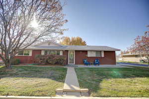View of front of house with a mature landscaping and brick siding