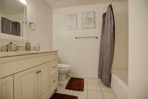 Main updated Bathroom featuring light tile patterned floors, vanity, and shower / bath combo