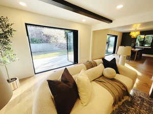 Living area with beamed ceiling, recessed lighting, a chandelier, and light wood-style floors