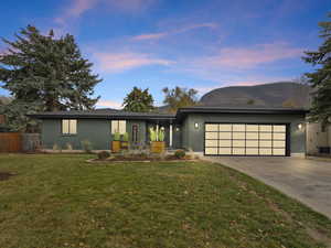 View of front of house with brick siding, driveway, a mountain view, and a garage