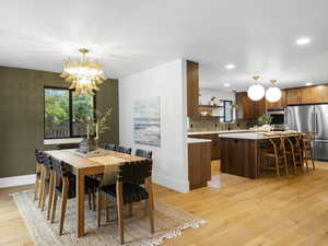 Dining room featuring light wood-type flooring, a chandelier, and recessed lighting