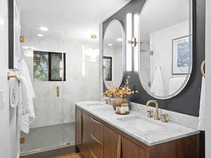 Full bath with double vanity, a shower stall, and recessed lighting